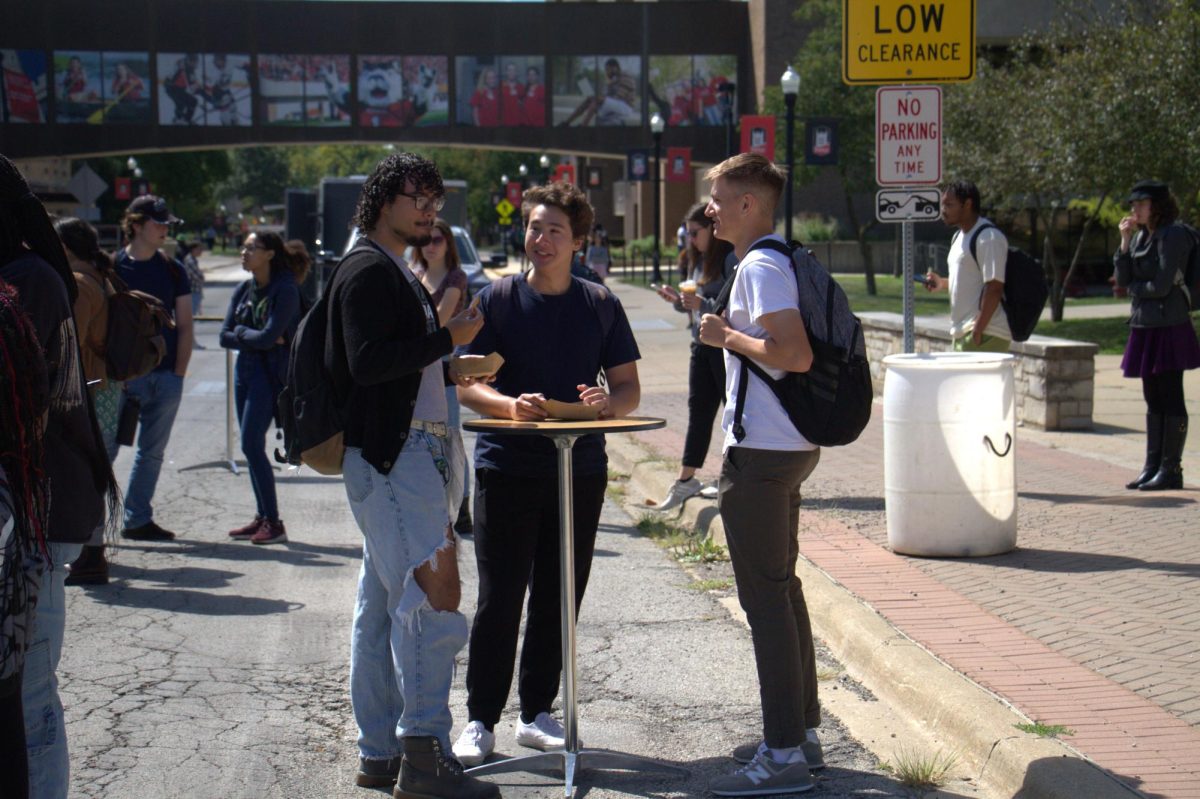 Trio of junior engineering majors Seth Gill (from left), Aidan Rodriguez, Aiden Gruner, eating lunch at the KaBao! food truck around noon Wednesday. Ka-Bao! was one of the featured food trucks for students near Holmes Student Center on Normal Road. (Ariyonna Mcgahee | Northern Star)
