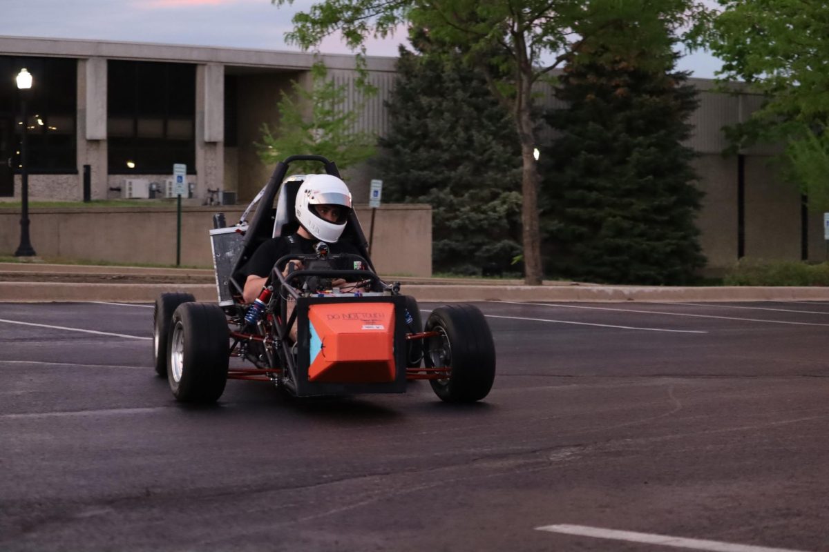 The Huskie Motor Sports club member drives their car in a parking lot. Huskie Motor Sports builds formula SAE cars that they use to compete in events. (Courtesy of Matt Eberle)