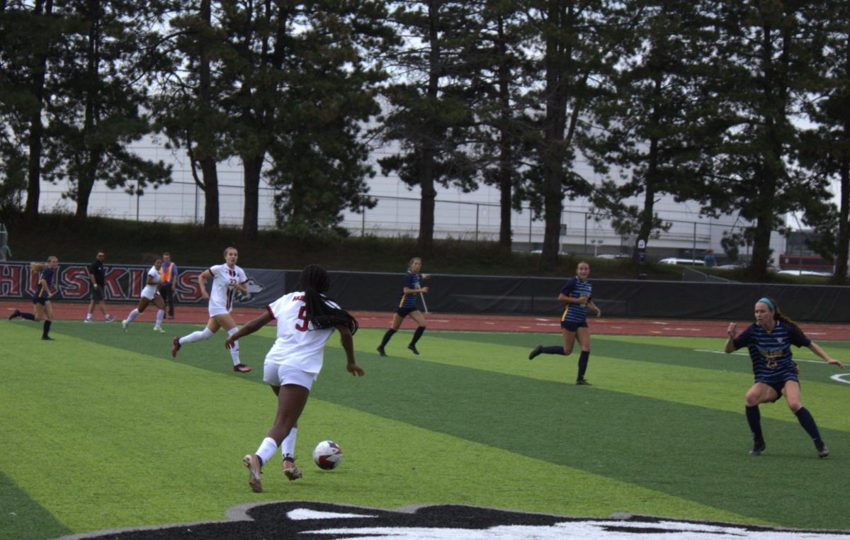 Freshman forward Tyra King (5) dribbles the soccer ball down the field as three Toledo defenders run to try and block King from reaching the goal on Thursday. (Melody Elbel | Northern Star)
