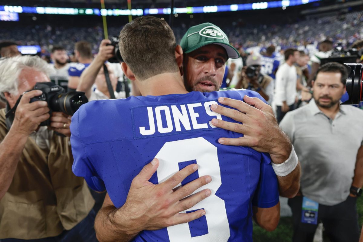 New York Giants quarterback Daniel Jones embraces New York Jets quarterback Aaron Rodgers (8) after an NFL preseason game on Aug. 26. (Adam Hunger | Associated Press)