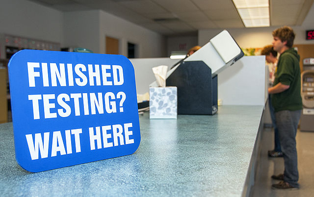  A sign instructing visitors to wait sits on a DMV desk. Secretary of State Alex Giannoulias Skip the Line program which took effect Sept. 1, is aiming to decrease the wait time at the DMV. (Courtesy of Wikimedia)