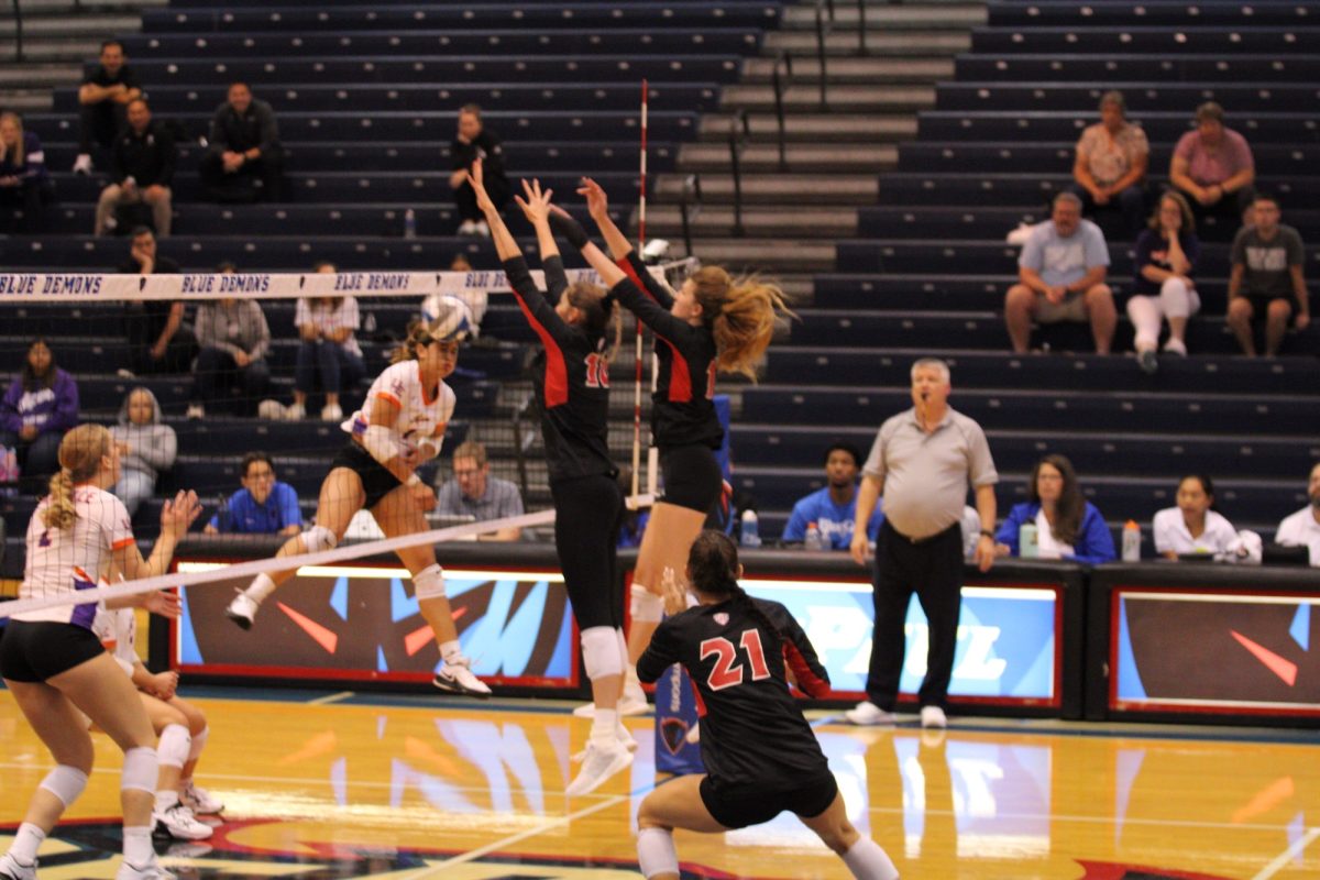 NIU senior opposite/outside hitter Emily Dykes and junior middle blocker Shannon Dunkin team up to block an attack by University of Evansville graduate student outside hitter Melanie Feliciano during Friday’s match at McGrath-Phillips Arena in Chicago. Dykes led the Huskies with 14 kills while Dunkin had a team-high seven total blocks in her Huskie debut. (Tim Dodge | Northern Star)