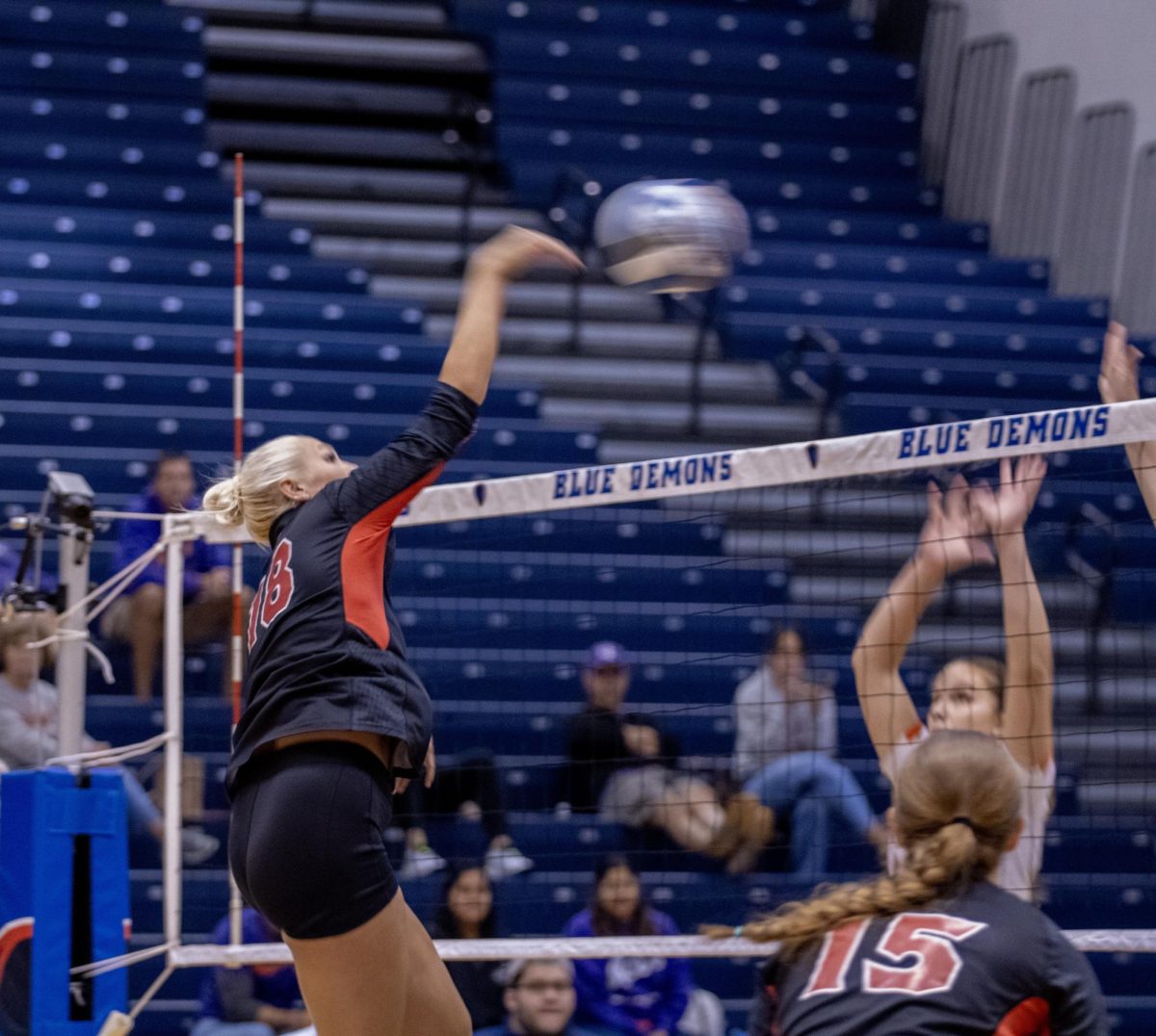 Sophomore middleblocker Savanah Brandt (18) spikes the ball over the net during Friday’s match against the University of Evansville at McGrath-Phillips Arena in Chicago. (Tim Dodge | Northern Star) 
