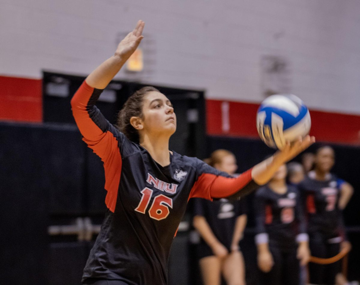 NIU junior setter Sophie Hurt (16) serves the ball during Friday’s match against the University of Evansville at McGrath-Phillips Arena in Chicago. (Tim Dodge | Northern Star) 
