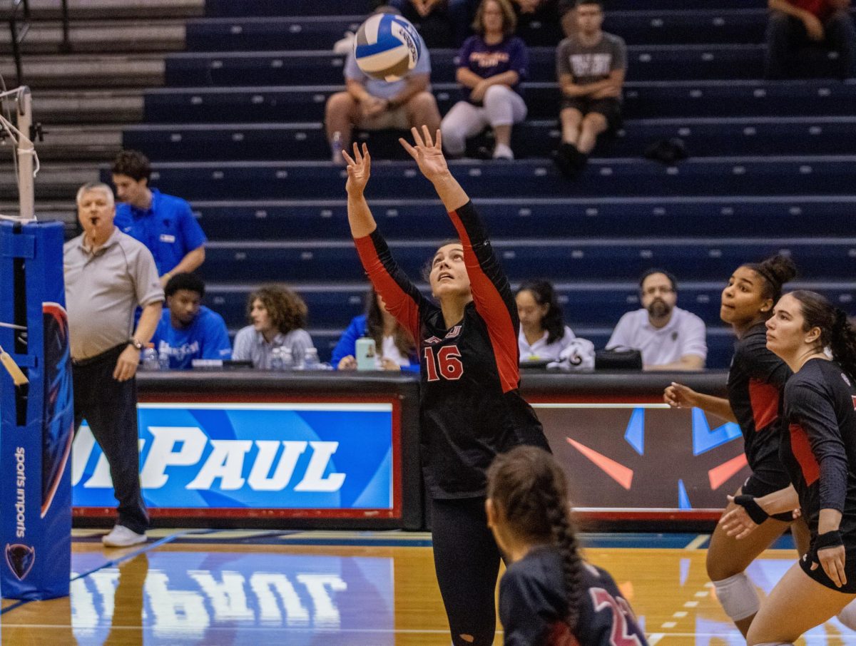 Junior setter Sophie Hurt sets a ball up for her teammate against the University of Evansville at the DePaul Invitational. The Huskies were defeated by the Purple Aces 3-1 on Friday. (Tim Dodge | Northern Star)