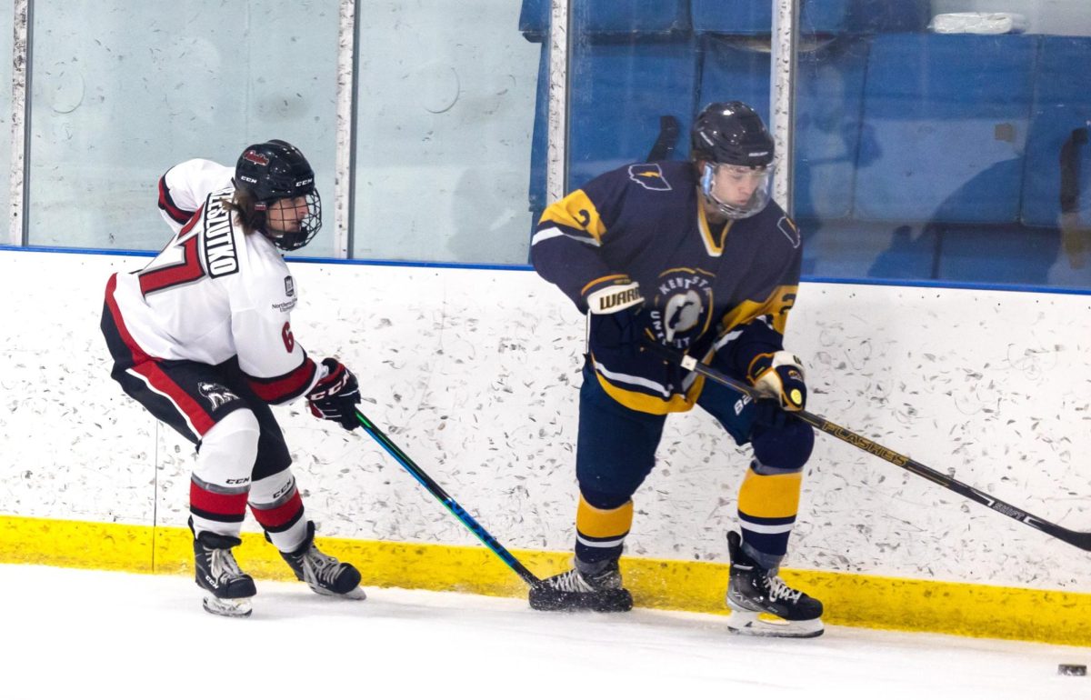 Sophomore forward Evan Rzeszutko forechecks a Kent State defender on Sept. 16. The Huskies fell to the Golden Flashes by a final score of 4-3. (Courtesy of NIU hockey) 