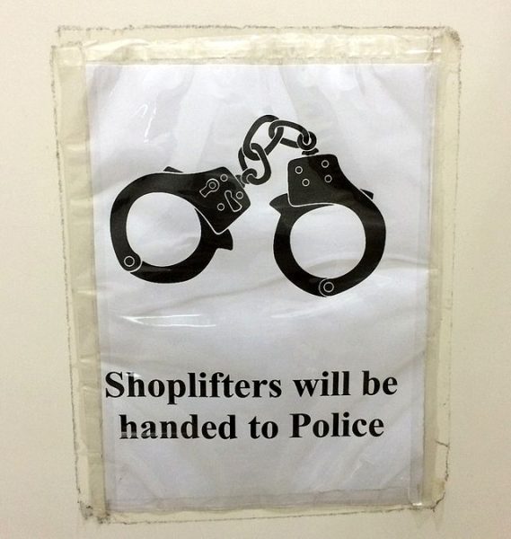 A poster that says Shoplifters will be handed to the Police is taped to a wall. Shoplifting can be a way for poor people to access necessities that they couldnt get otherwise. (Katangais | CCA 2.5)