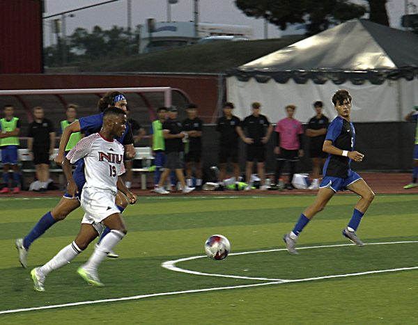 Midfielder Eddie Knight (19) dribbles past Auroras defenders going in for his second goal in the first half on Monday. Knight scored three goals against Aurora leading the Huskies to Victory 7-2. (Nyla Owens | Northern Star)