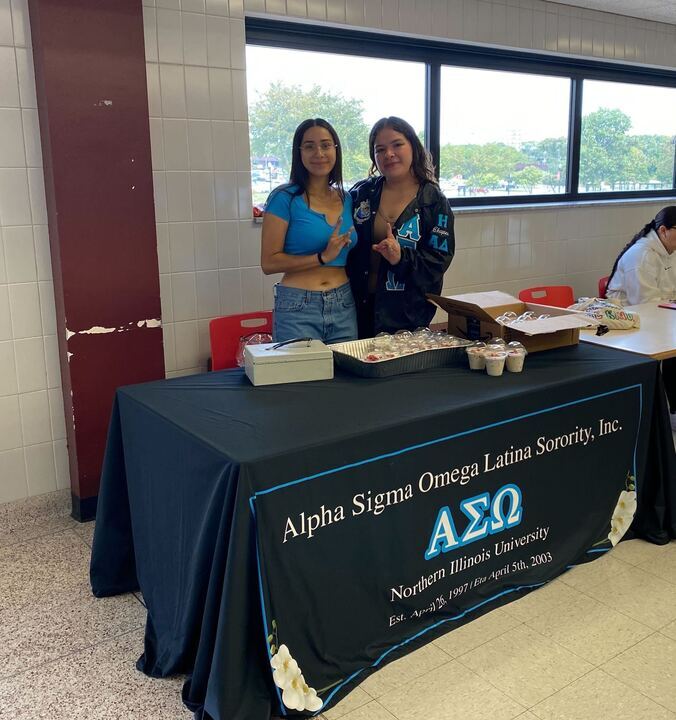 Janet Rodriguez (left), president and academic chair of sorority Alpha Sigma Omega, and Liliana Guerrero, secretary, co-fundraising and co-public relations of ASO, stand at a fundraising table in DuSable Hall. The sorority had fresas con crema available for purchase. Over the summer, NIUs student involvement made changes to its regulations for student organizations hosting food fundraisers. (Alberto Briones | Northern Star)
