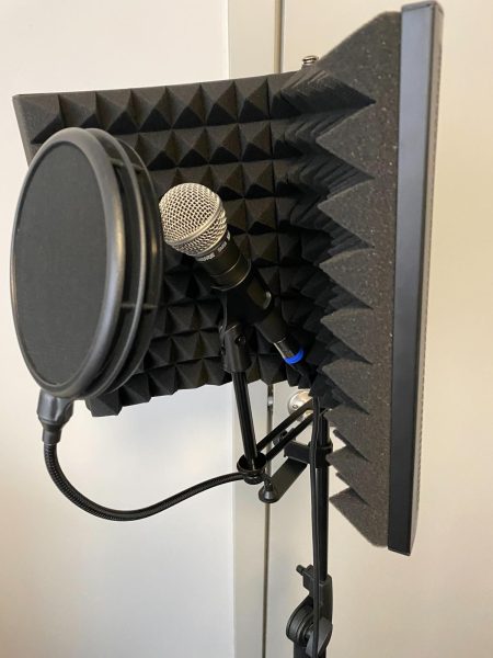 A microphone, pop filter and an acoustic foam panel stand together, ready for use. Making and recording music on a budget is possible for college students and isn’t as daunting as people may think. (Eli Tecktiel | Northern Star)