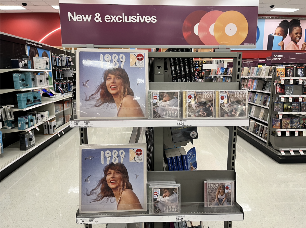 1989 (Taylors Version) album on vinyl and CD sit next to each other on a stand in Target. Taylor Swifts re-recorded album features five new tracks, or vault songs. (Sarah Rose | Northern Star)