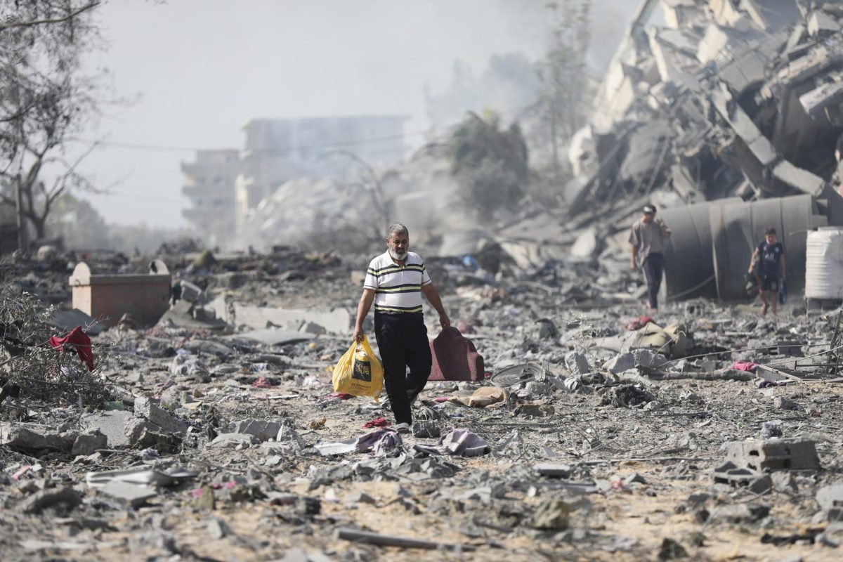 Palestinians walk by destroyed buildings in the outskirts of Gaza city. A conflict between Israel and Hamas has been ongoing since a surprise attack on Oct.7. (Ali Mahmoud | AP)