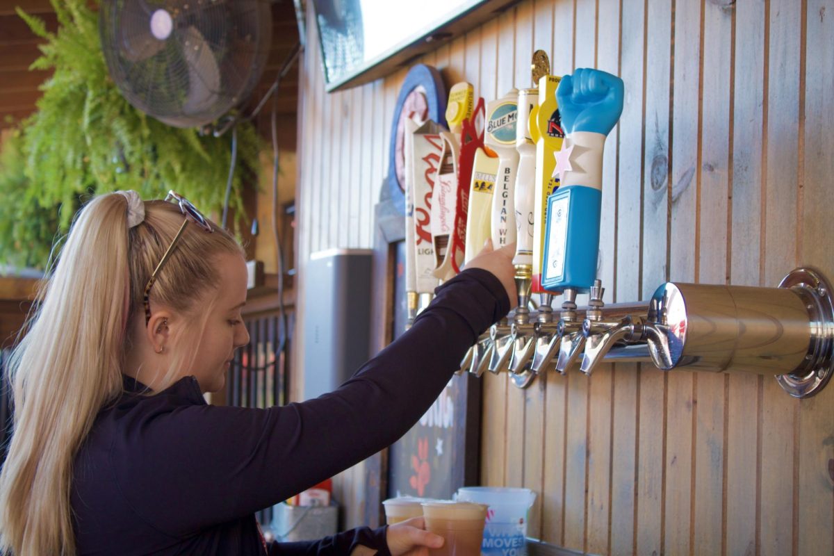 Jordan Francis, a bartender at Fattys Pub and Grille, pours a beer. Francis talked about her experience of being a college town bartender. (Josephine Dunmore | Northern Star) 