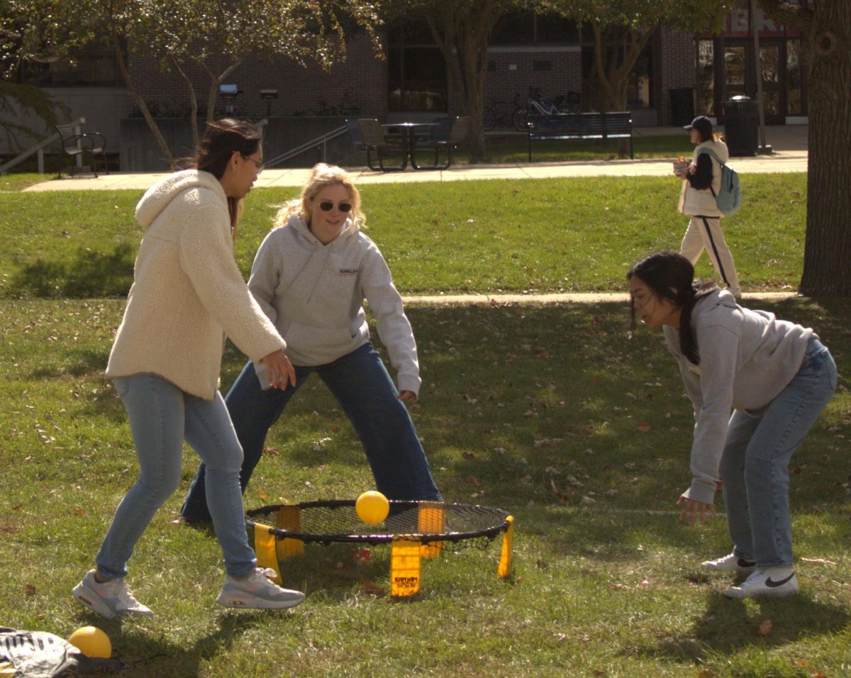Layla Tiongco (left), a junior kinesiology major, Sofia Didenko, a sophomore communications media study major, and Kamila Vergara, a junior communications media study major, play a game of spikeball during the Homecoming Kick Off on Monday in the MLK Commons. (Ryanne Sandifer | Northern Star)

