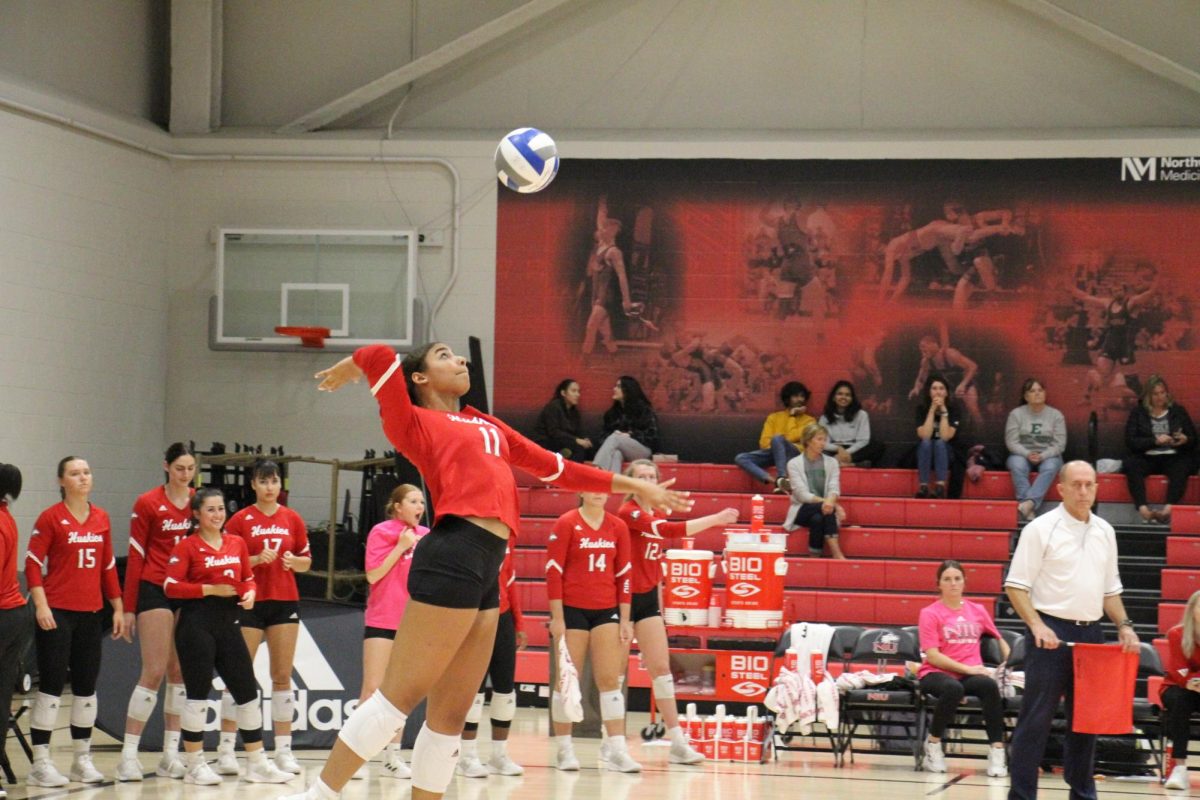 Junior middle blocker Charli Atiemo (11) serves a hit toward Eastern Michigan’s team on Thursday. Atiemo was named the MAC West Defensive Player of the Week on Monday. (Ariyonna McGahee | Northern Star)