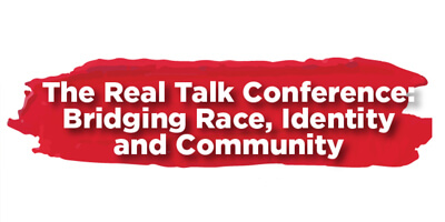 White letters say The Real Talk Conference: Bridging Race, Identity, and Community on red paint. The conference will feature conversations about ways to combat systematic racism and influence campus diversity from distinguished speakers. (Courtesy of Jami Kunzer)