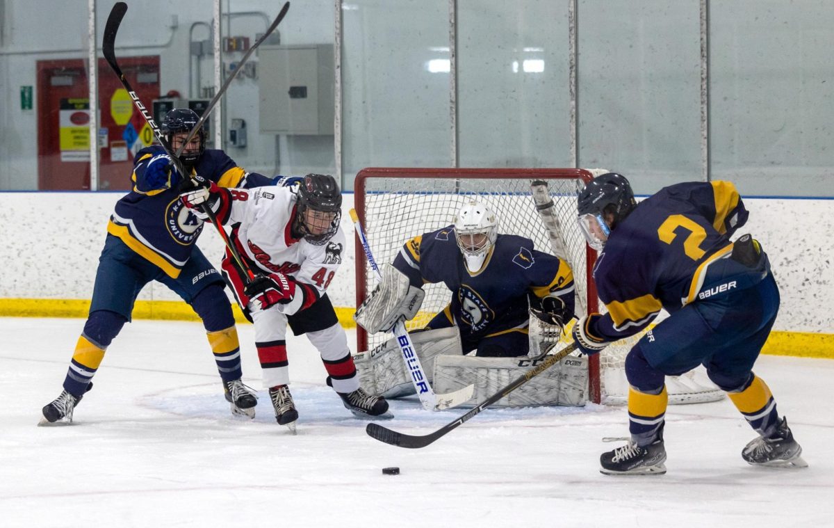 Freshman forward Robbie Zimmerman battles for the puck in front of the net on Sept. 16. Zimmerman scored a hat-trick in Fridays game against Midland University. (Courtesy of NIU Hockey) 