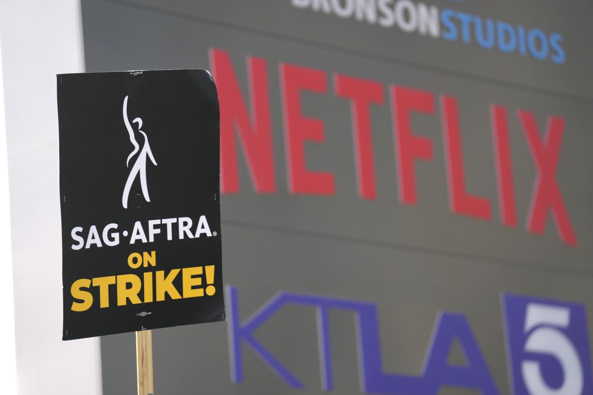 A sign in support of the writers strike stands visible outside Netflix headquarters on Sept. 27, 2023, in Los Angeles. Now that the writers strike is over, Netflix will resume production of several TV shows. (AP Photo/Chris Pizzello)