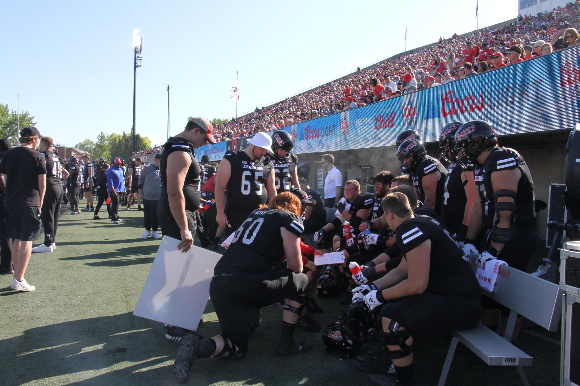 The Huskies offensive line has a team discussion in the third quarter on Sept. 9 against Southern Illinois University. The Huskies were defeated 14-11. (Nyla Owens | Northern Star)