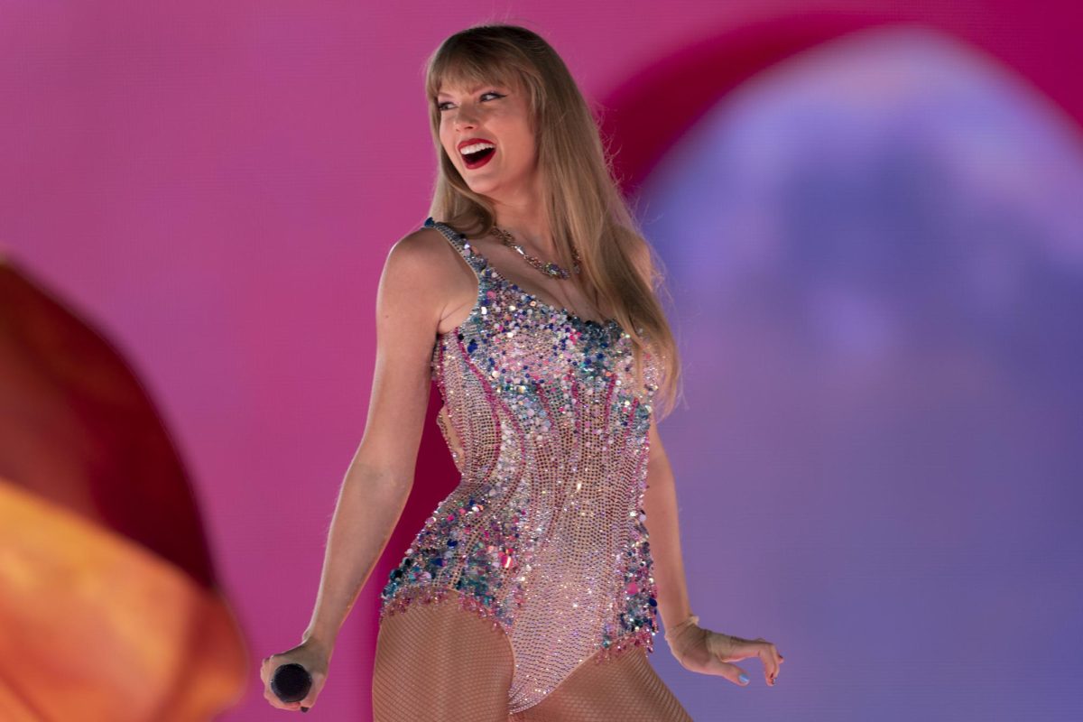 Taylor Swift performs in a pink and blue sequined bodysuit during her Eras tour. Since rumors of Swift dating Chiefs player Travis Kelce blew up over social media, football fans and Swifties alike are confused about what the big deal is. (AP Photo/George Walker IV, File) 