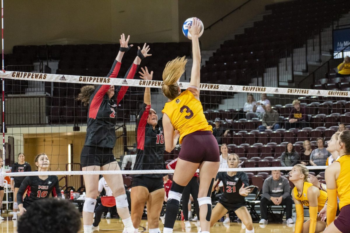 NIU graduate right side hitter Isabelle Percoco (2) and sophomore middle blocker Savanah Brandt (18) attempt to block Central Michigan University junior outside hitter Lauren Schrocks (3) attack attempt during Saturdays meeting, featuring the conference-rivaling Huskies and Chippewas. Percoco led the Huskies efforts with 14 kills to match her career-high and assisted on three blocks in NIUs 3-1 loss. (Josie Ransley | CMU Athletics)