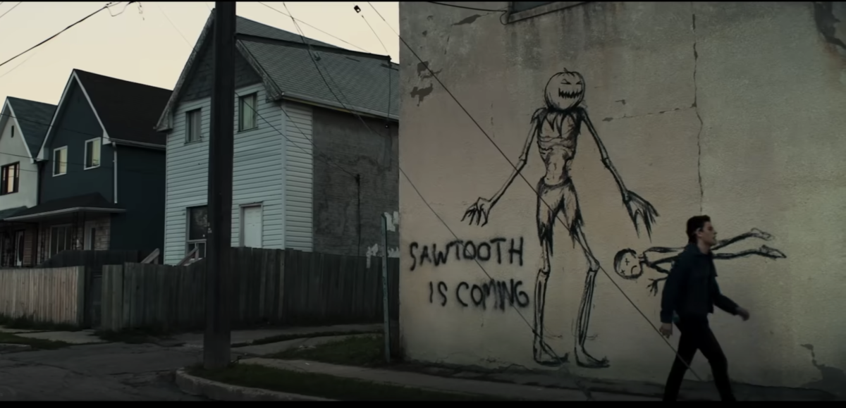A screen still from the trailer for the film Dark Harvest depicts graffiti on a building warning those who walk by that Sawtooth is coming. The film releases on Roku on Oct. 13 and tells a haunting story of a cursed midwestern town. (Courtesy of YouTube)