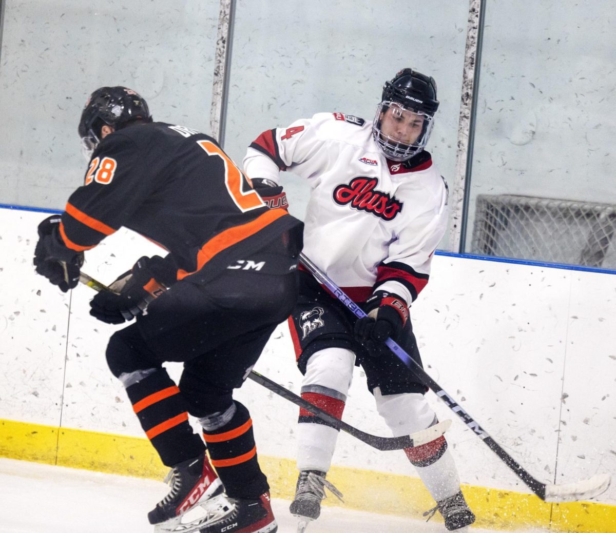Junior defenseman Keaton Peters battles for the puck in NIU Hockeys game against the University of Jamestown on Oct. 13. The Huskies fell to the Midland University Warriors on Friday by a final score of 5-3. (Courtesy of NIU Hockey)