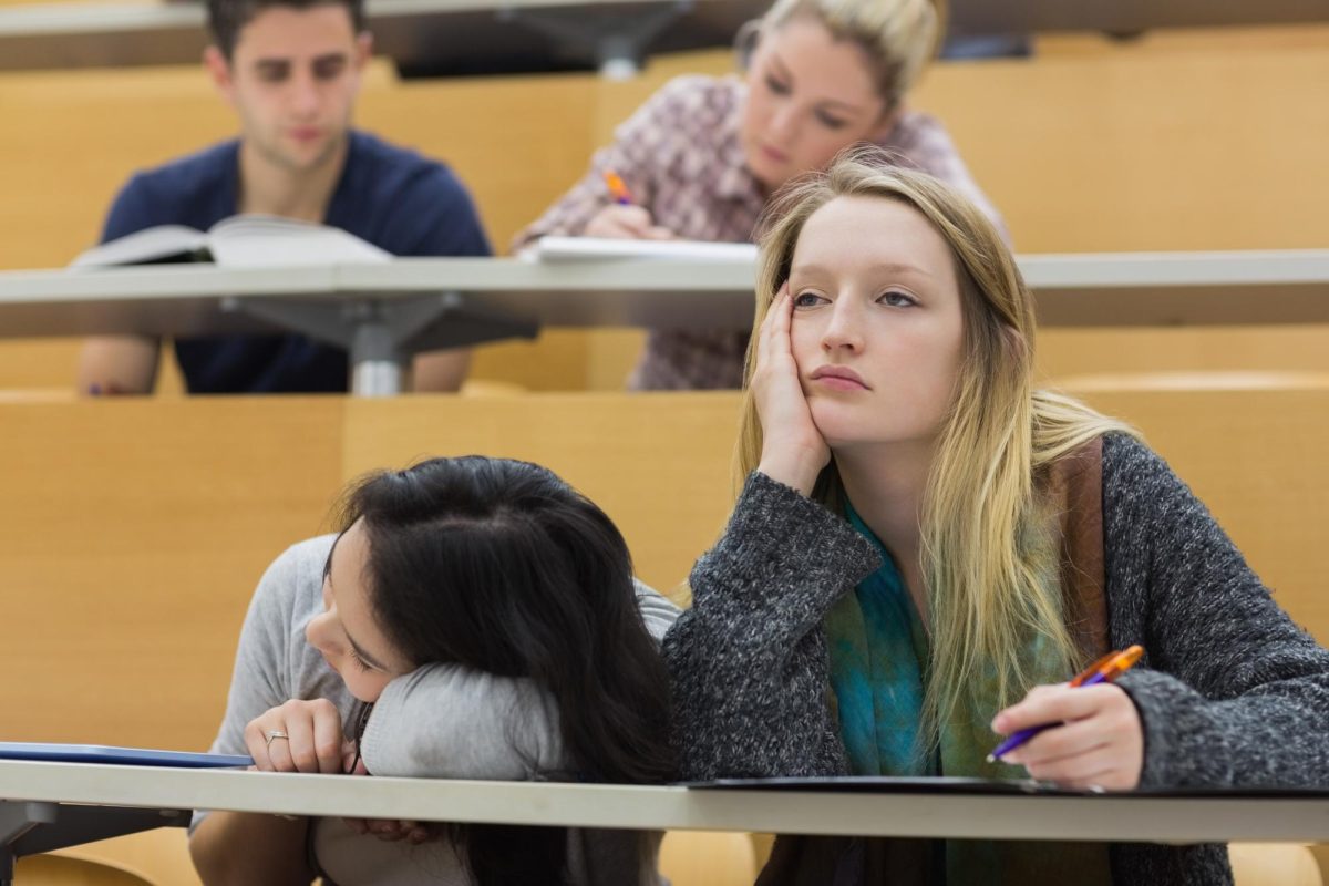 A+student+lays+her+head+on+a+table+while+the+other+student+rests+her+head+on+her+hand.+An+NIU+alum+recommends+quality+sleep+over+quantity+of+hours.+%28Getty+Images%29