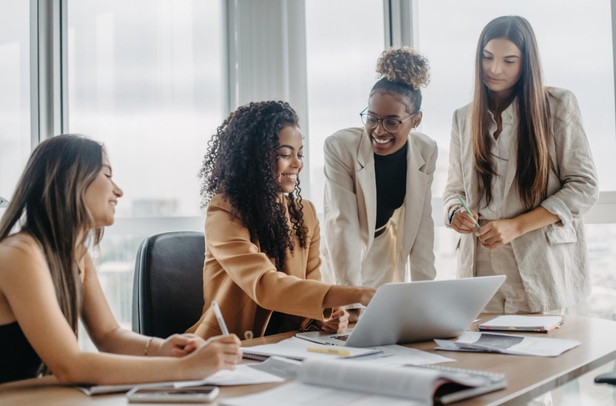 A group of women are gathered around a table. Senior Opinion Columnist Emily Beebe believes women deserve more appreciation in the workforce. (Courtesy of Getty Images)  