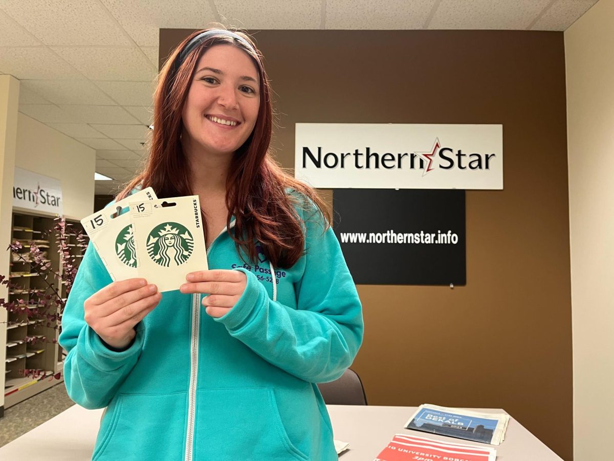 Cecilia Lucente, a graduate student on the clinical mental health counseling track, shows off two $15 Starbucks gift cards. Lucente is the winner of the Northern Star’s Halloween Costume Contest. (Bridgette Fox | Northern Star)