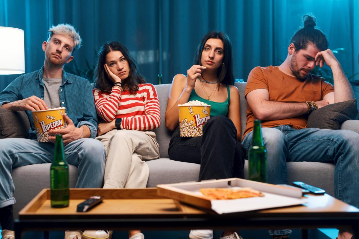 Four+people+watch+a+movie+with+disappointed+expressions.+Senior+Opinion+Columnist+Emily+Beebe+believes+live-action+remakes+are+not+up+to+par+with+animated+classics.+%28Courtesy+of+Getty+Images%29