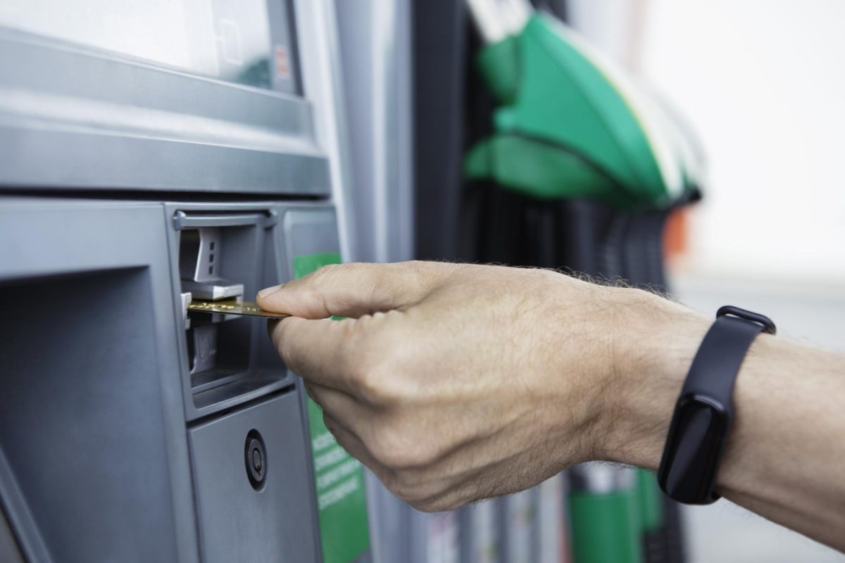 A hand sticks a credit card into a gas pump card reader. Gas prices across the country are falling. (Getty Images) 