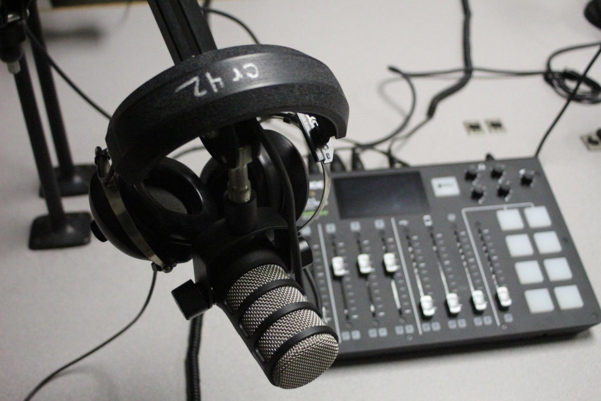 A microphone and a set of headphones hang among recording equipment in the Northern Star’s recording studio. Opinion Columnist Kahlil Kambui believes shorter albums are more meaningful. (Joey Trella | Northern Star)