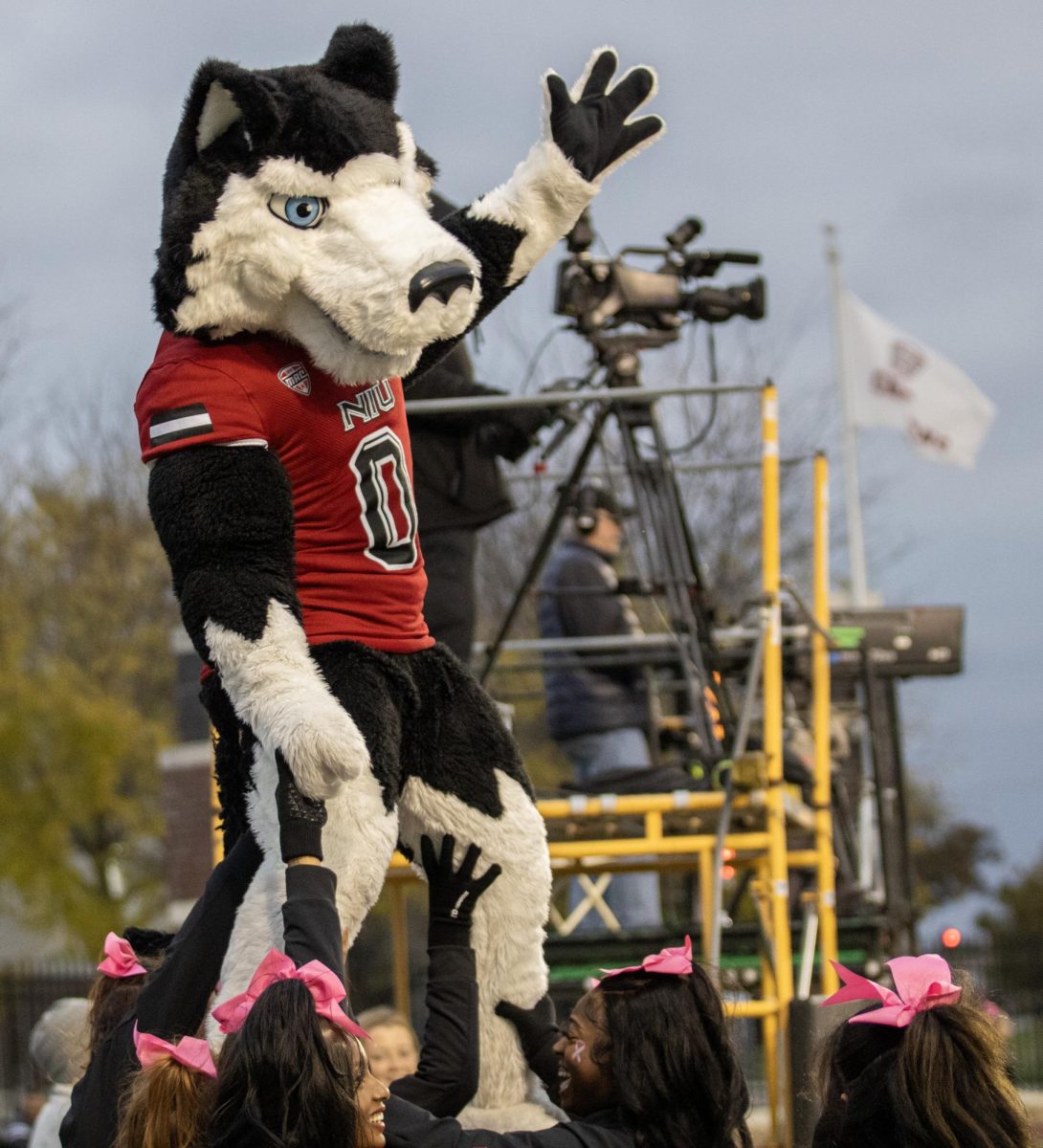 Victor E. Huskie cheers to the crowd as the NIU cheerleaders raise him up late during NIUs game against Eastern Michigan on Oct 21. The Huskies defeated the Eagles 20-13. (Tim Dodge | Northern Star)