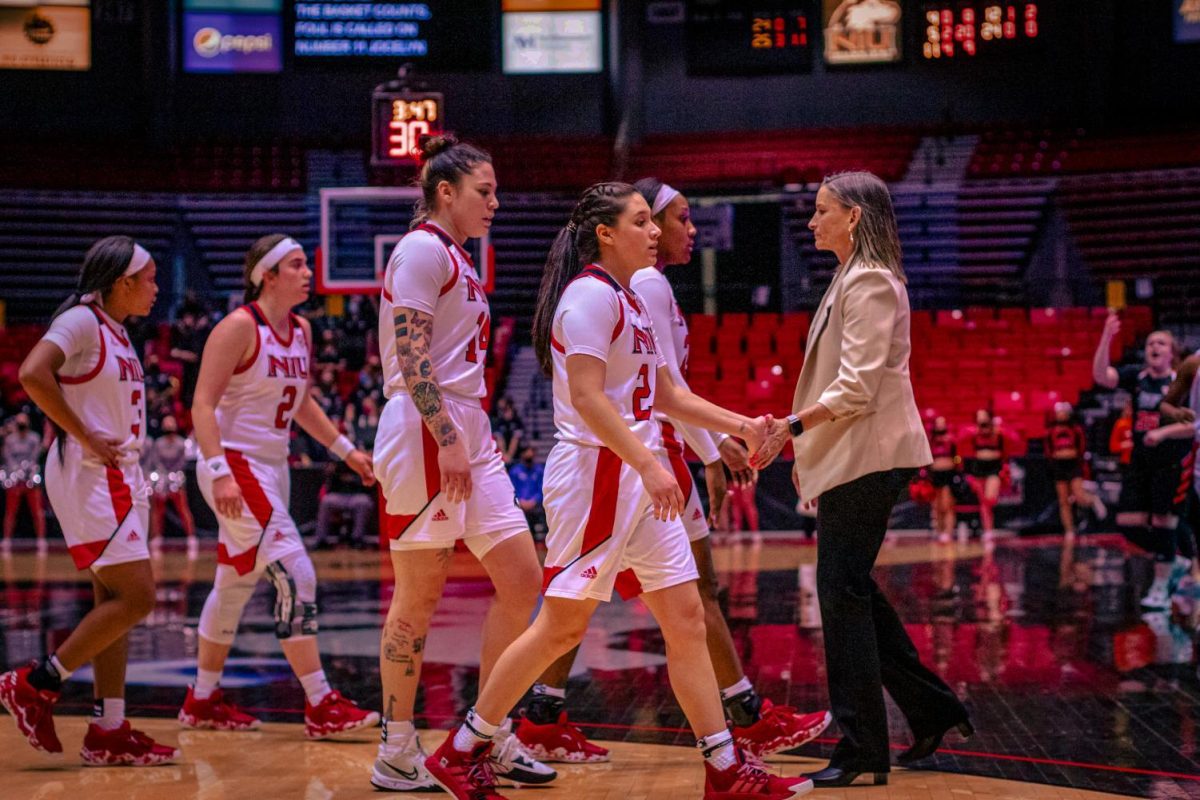 2022 redshirt senior guard Paulina Castro gives coach Lisa Carlsen a high five as the rest of the womens basketball team heads toward the sideline after its game against Bowling Green on Feb. 2, 2022. (Summer Fitzgerald | Northern Star File Photo) 