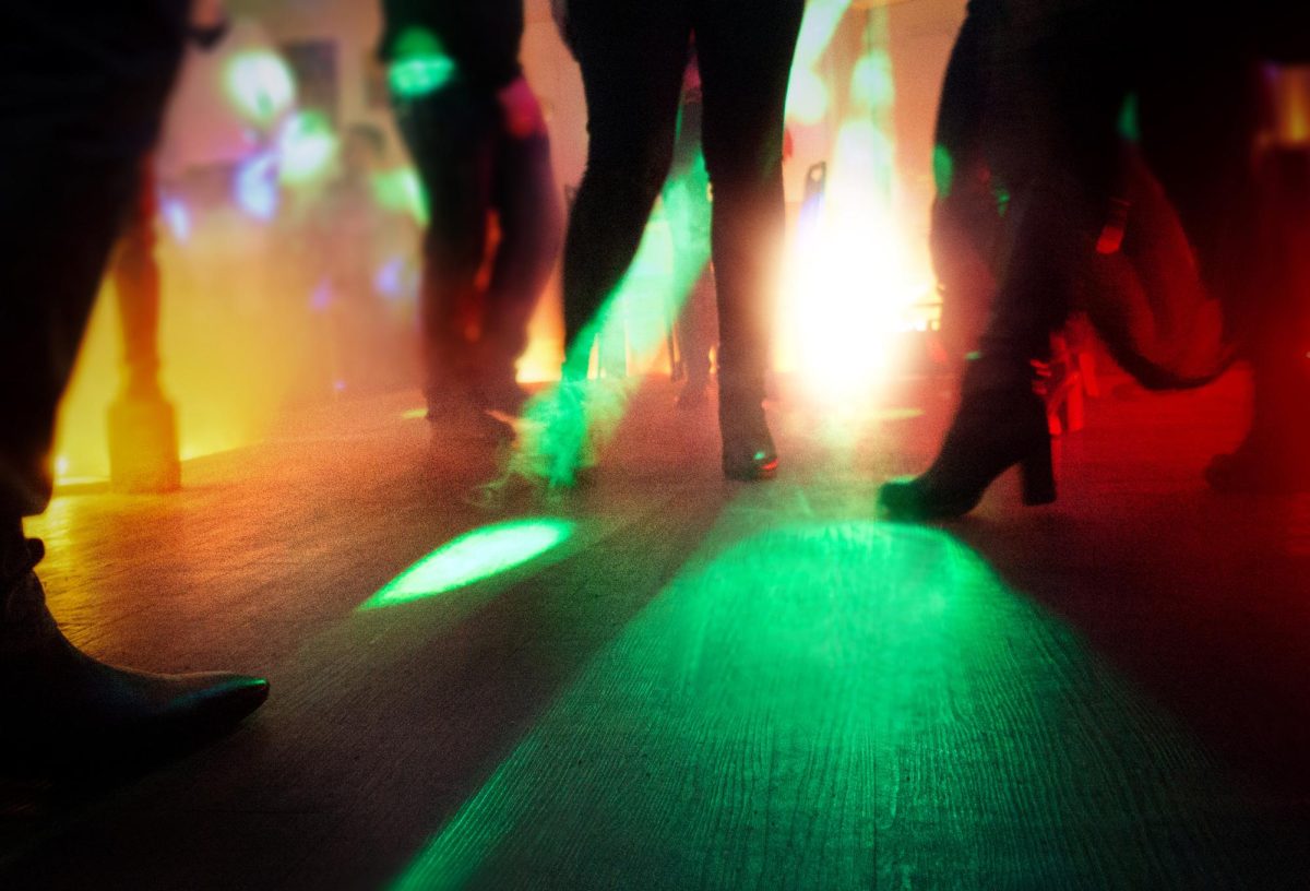 A+group+of+people+dance+on+a+hardwood+floor+with+red+and+green+lights.+Dance+Dimension+is+set+to+hold+its+third+annual+Tinsel+an+Tutu+event+in+December.+%28Courtesy+of+Getty+Images%29