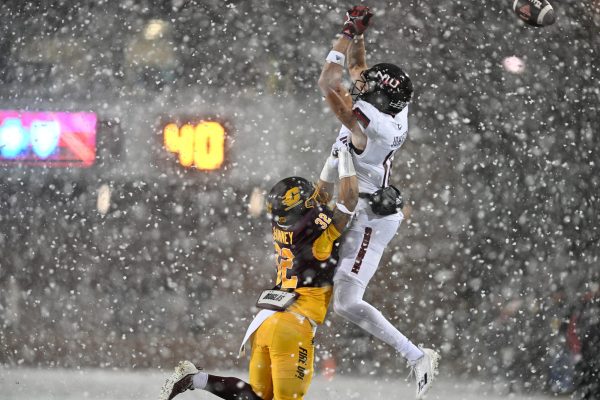 Redshirt freshman wide receiver Jalon Johnson attempts to catch the ball in the snow against Central Michigan last Tuesday. The Huskies will look to reclaim the Bronze Stalk Trophy on Tuesday against Ball State. (Courtesy of NIU Athletics)