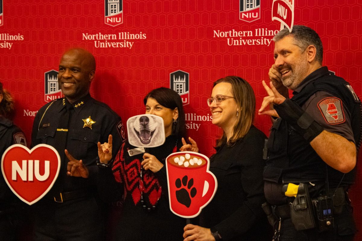 NIU President Lisa Freeman and Executive Assistant Liz Wright pose with members of the NIU police force Thursday at the President’s Holiday Gathering in the Altgeld Hall Auditorium. The Holiday Gathering was open to staff and students to connect with each other. (Sean Reed | Northern Star)