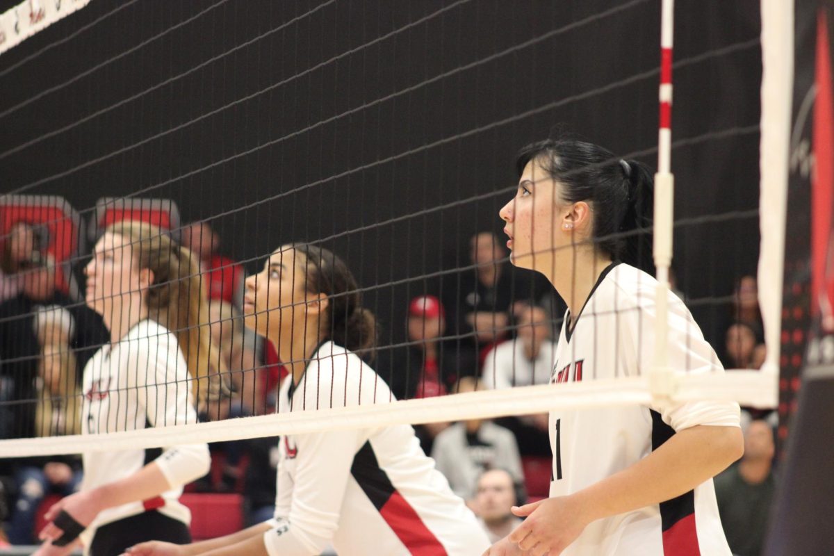 From left: NIU senior opposite/outside hitter Emily Dykes (12), junior middle blocker Charli Atiemo (11) and sophomore outside hitter Nazli Güvener (17) look on during Friday’s match against the University of Toledo at Victor E. Court. The Huskies fell in four sets to the Rockets, extending their losing streak to six consecutive matches. (Josephine Dunmore | Northern Star)