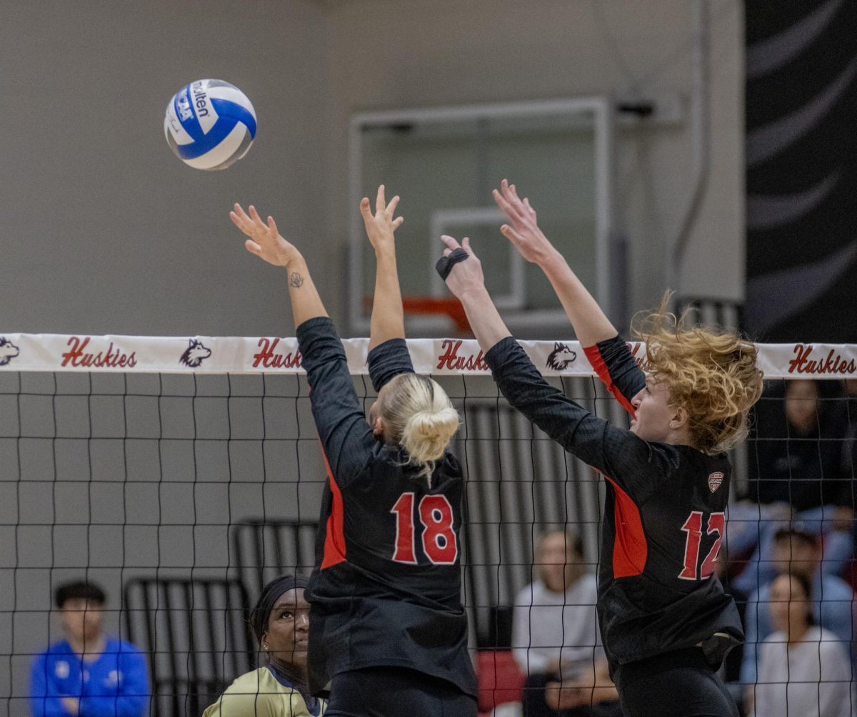 NIU senior opposite/outside hitter Emily Dykes (12) and sophomore middle blocker Savanah Brandt (18) team up to block over the net against the University of Akron on Oct. 27. The Huskies ended their season with a 3-0 loss to Western Michigan on Wednesday. (Tim Dodge | Northern Star)