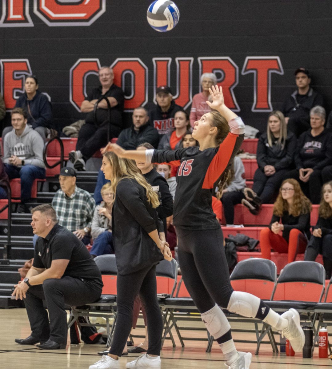 NIU senior setter Ella Mihacevich (15) jumps to serve the ball during NIU volleyballs match against the University of Akron on Oct. 27. The Huskies are preparing to close out their season against first-place Western Michigan on Wednesday. (Tim Dodge | Northern Star)