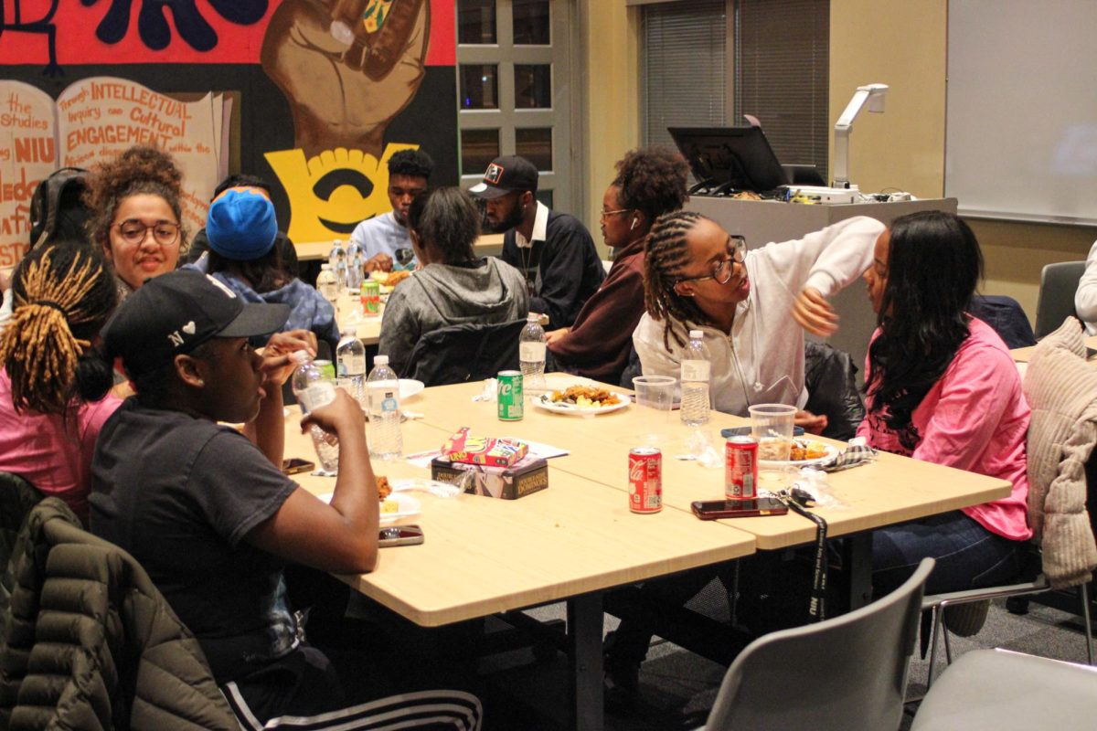 Students sit at a table in the Center for Black Studies. A variety of food and board games were provided at the celebration of the ceremony. (Gabby Crabtree | Northern Star)
