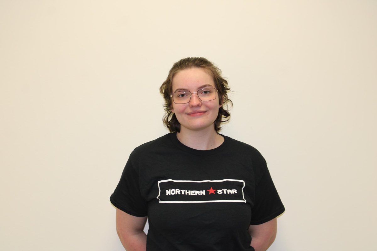 Written Managing Editor Bridgette Fox smiles in a Northern Star t-shirt. Fox will graduate Dec. 17 with a bachelor’s degree in English. (Nyla Owens | Northern Star)