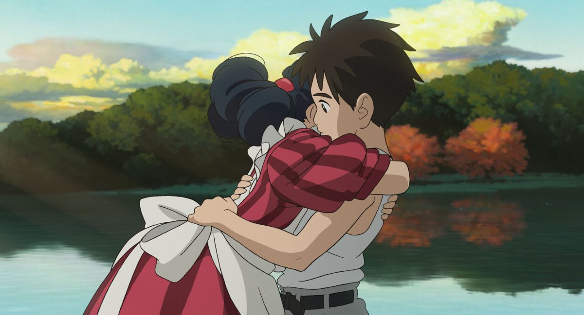 A+girl+in+a+red+dress+hugs+a+boy+in+front+of+a+lake.+Studio+Ghiblis+newest+film+The+Boy+and+the+Heron+will+be+Director+Hayao+Miyazakis+first+movie+in+ten+years.+%28Courtesy+of+Studio+Ghibli%29