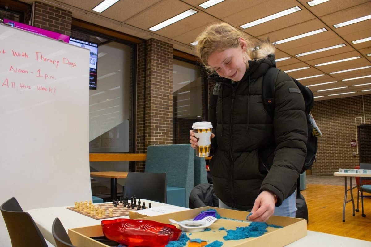 Freshman political science major Samantha Mostaert plays with kinetic sand at the Stress Less Zone on the first floor of the Founders Memorial Library. NIUs Counseling and Consultation services advises students to practice destressing activities during finals week. (Sean Reed | Northern Star)