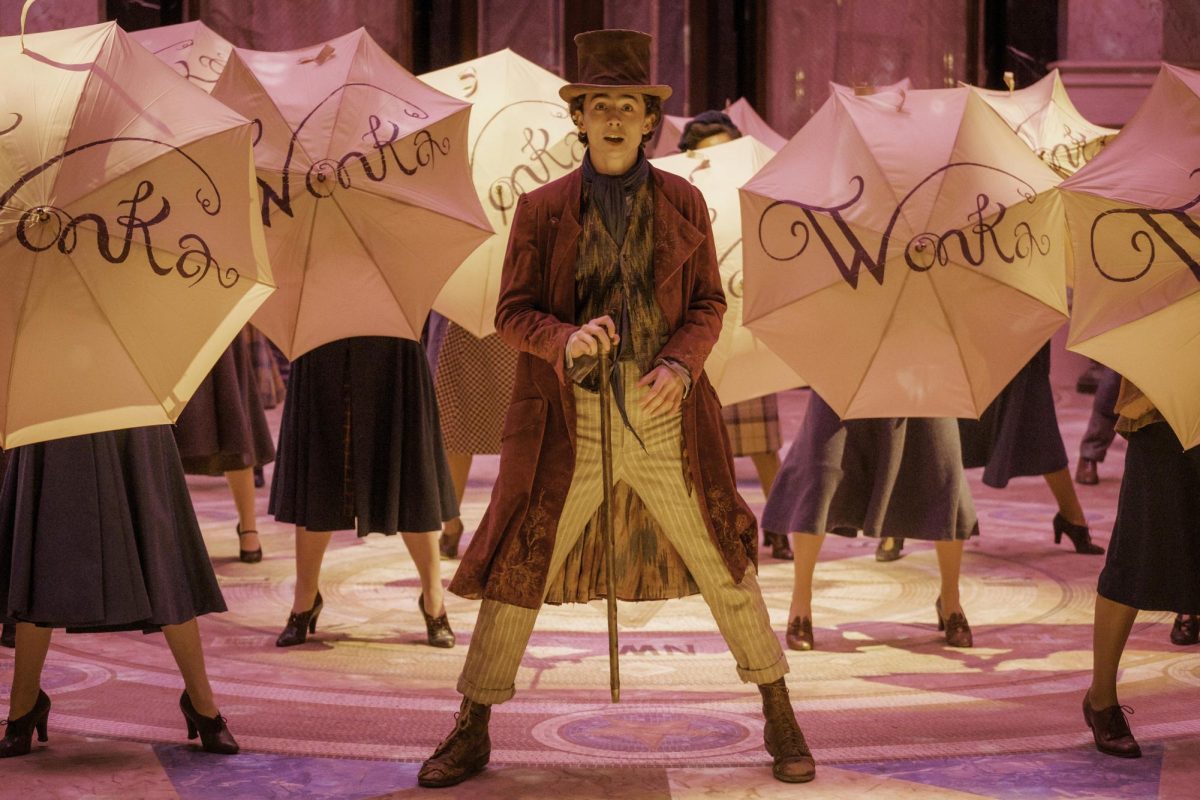 Timothée Chalamet stands in the center of several open umbrellas. “Wonka” releases in theaters on Dec. 15. (Jaap Buittendijk/Warner Bros. Pictures via AP)