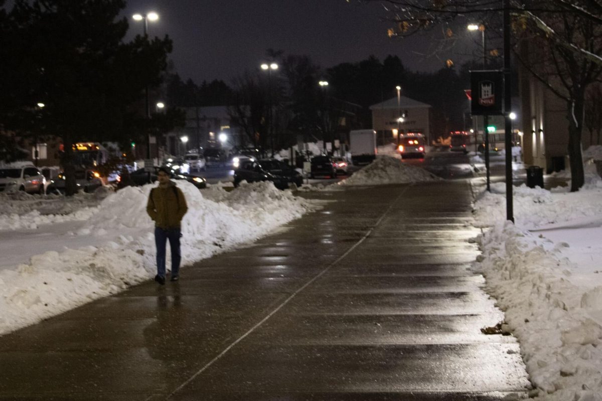 Shaan Keswani, a graduate student studying pre-medicine, walks down the sidewalk Monday through MLK Commons. A winter weather advisory is in effect until 9 a.m. Tuesday. (Sean Reed | Northern Star)
