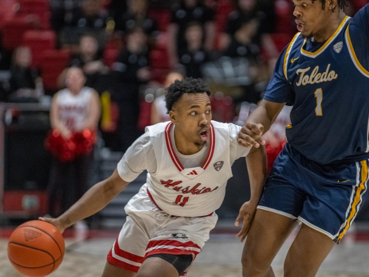 Junior guard David Coit (11) hooks past Toledo redshirt freshman forward Javan Simmons (1) with possession of the ball. Coit led the team in scoring, with 23 of the team’s total 73 points attributed to him. (Tim Dodge | Northern Star)