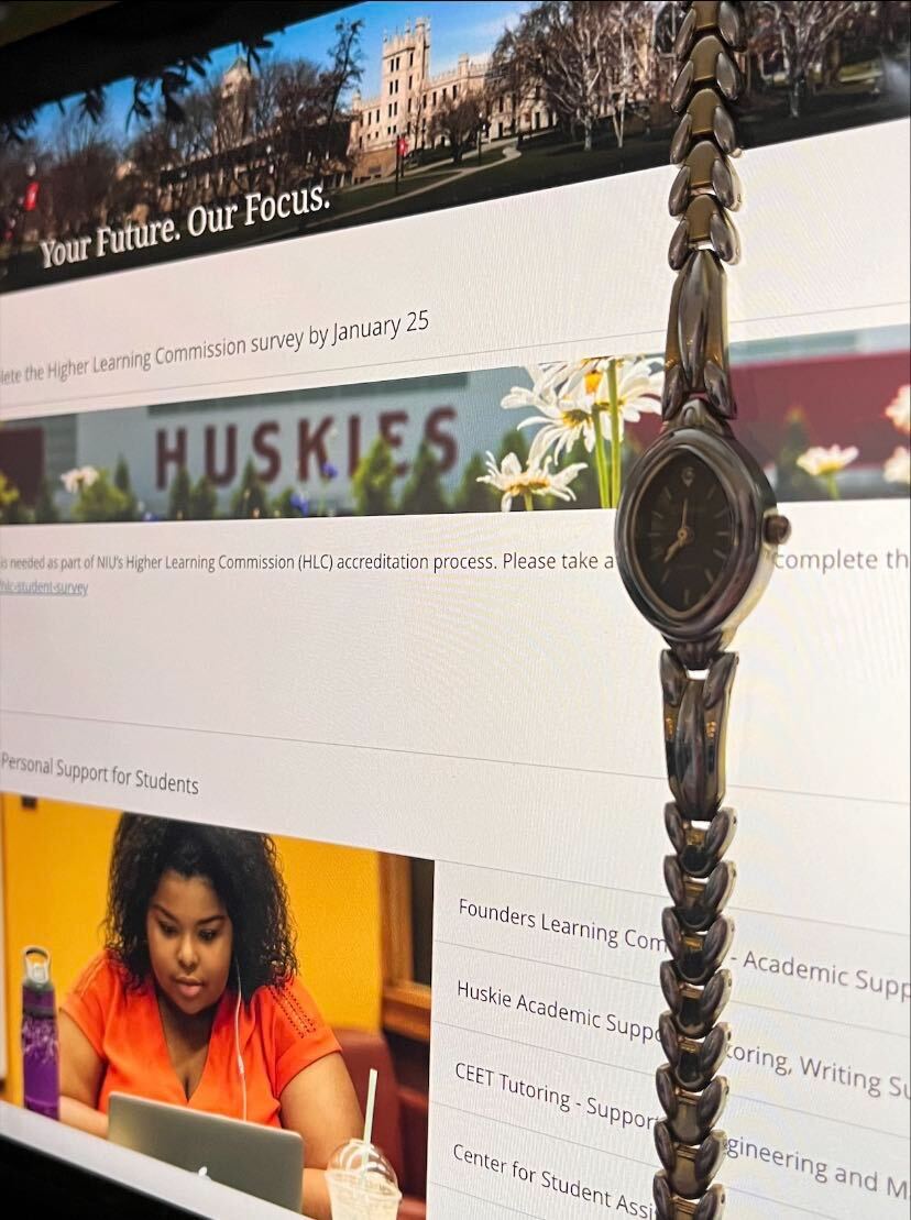 A ticking watch hangs in front of a computer screen opened to the Blackboard home page. Accelerated courses move at a quicker rate than some students expect. (Northern Star | Photo Illustration)