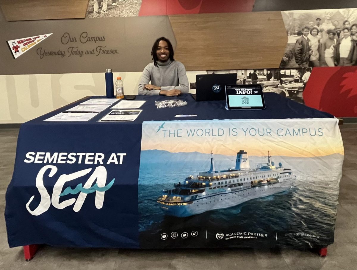 TJ Hill, the regional director of Semester at Sea, sits at an informational desk at the Holmes Student Center on Thursday. Semester at Sea is a program that offers students a study abroad experience that visits many countries while taking classes on a cruise ship. (Sofia Didenko | Northern Star)
